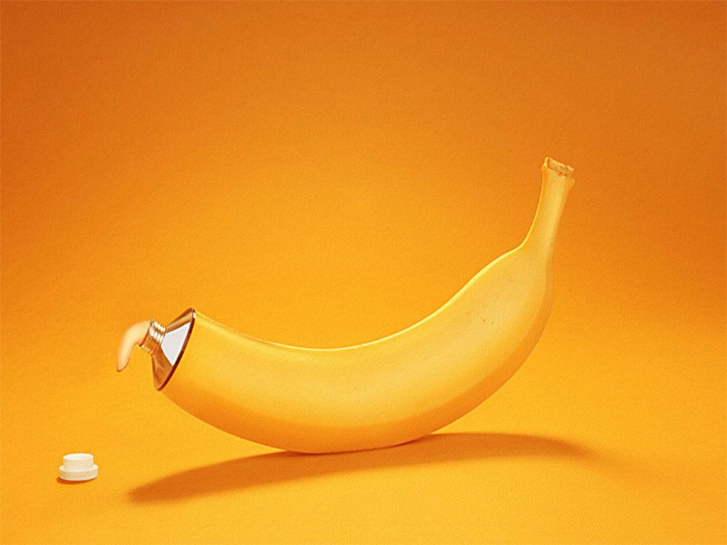 A banana is sitting on an orange background - Banana