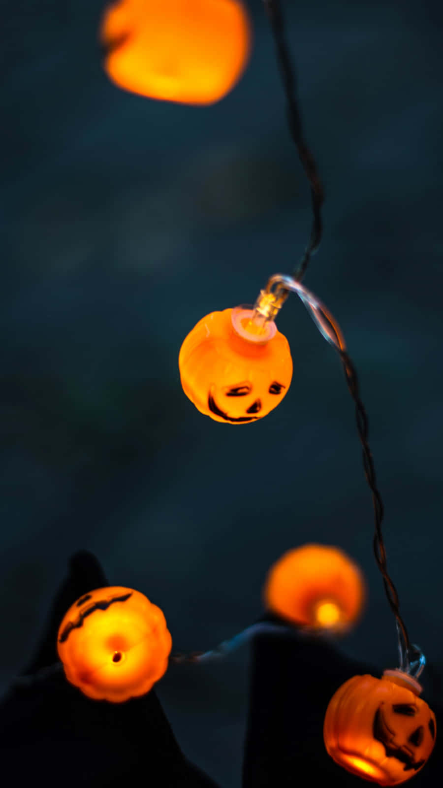 A string of orange light bulbs with pumpkin faces - Cute Halloween