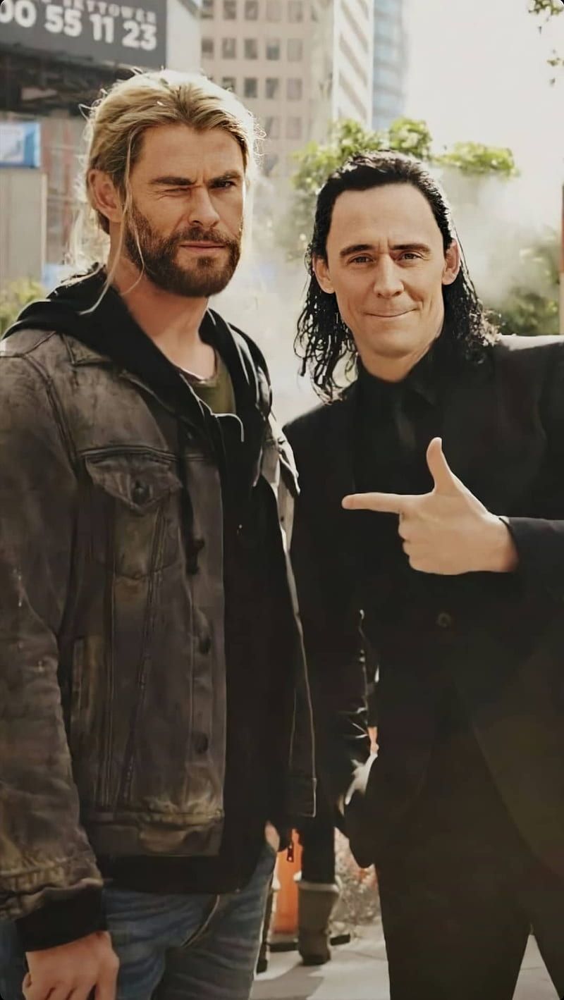 Two men standing next to each other with their hands up - Thor