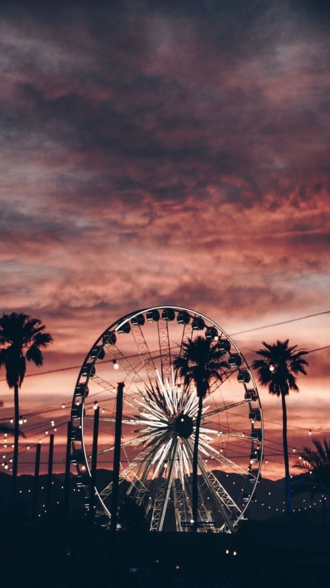 A ferris wheel is in the sky at sunset - Summer, California