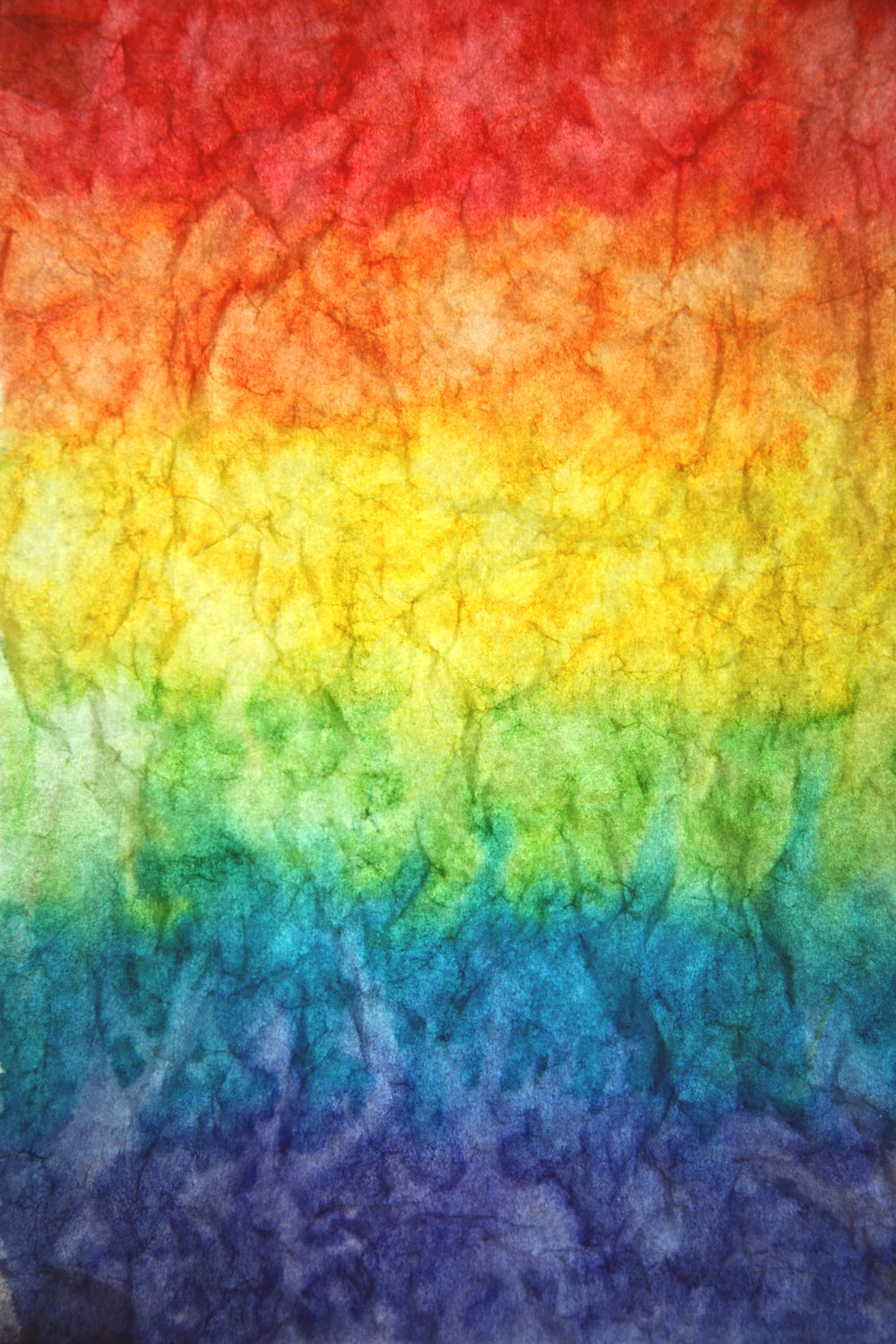 A photograph of a rainbow gradient on a piece of crumpled paper. - Gay