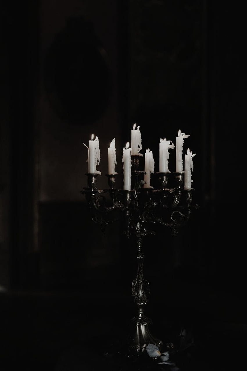 A candelabra with white candles in a dark room - Gothic