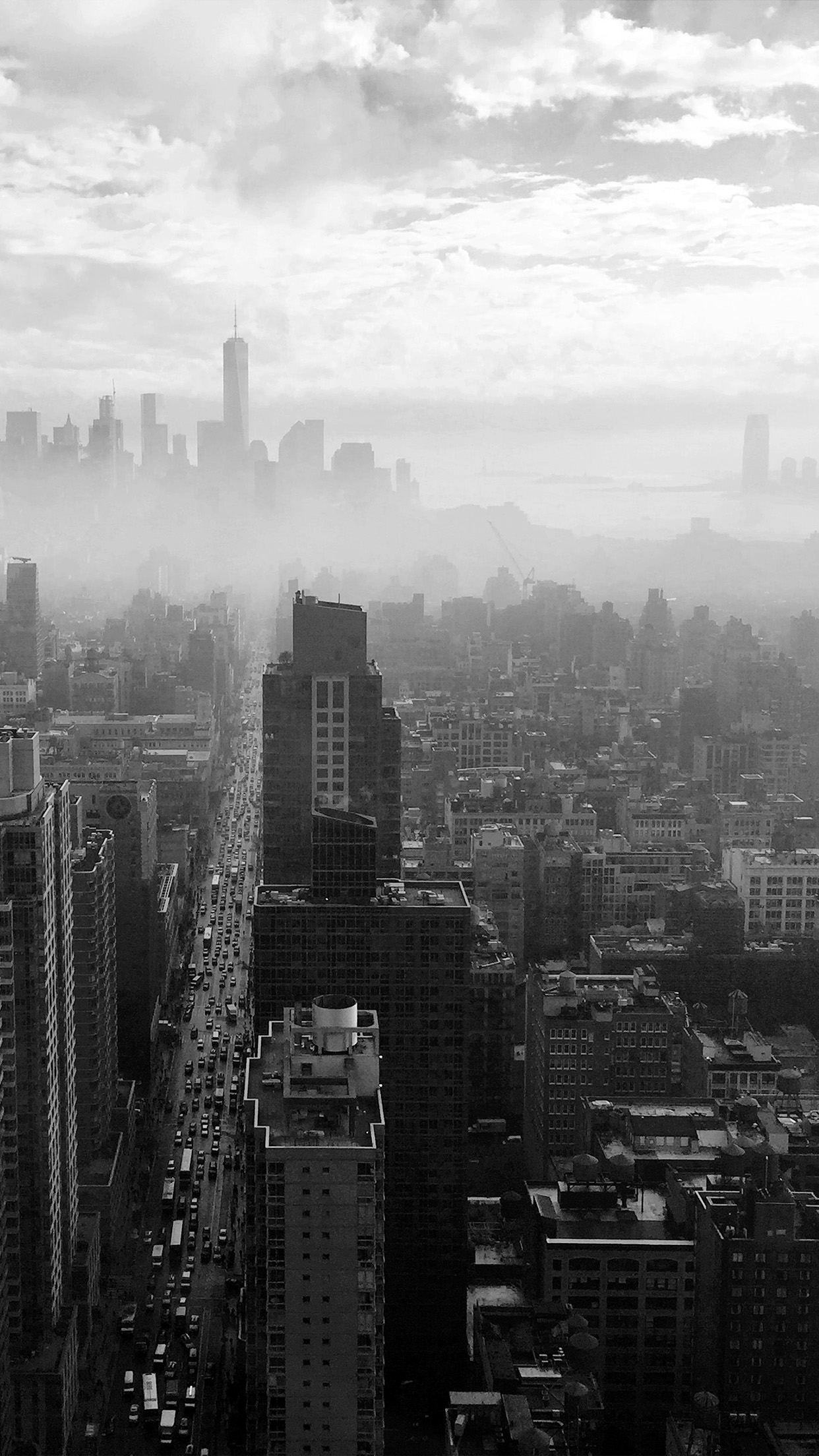 A black and white photo of a city skyline with skyscrapers and cars. - New York
