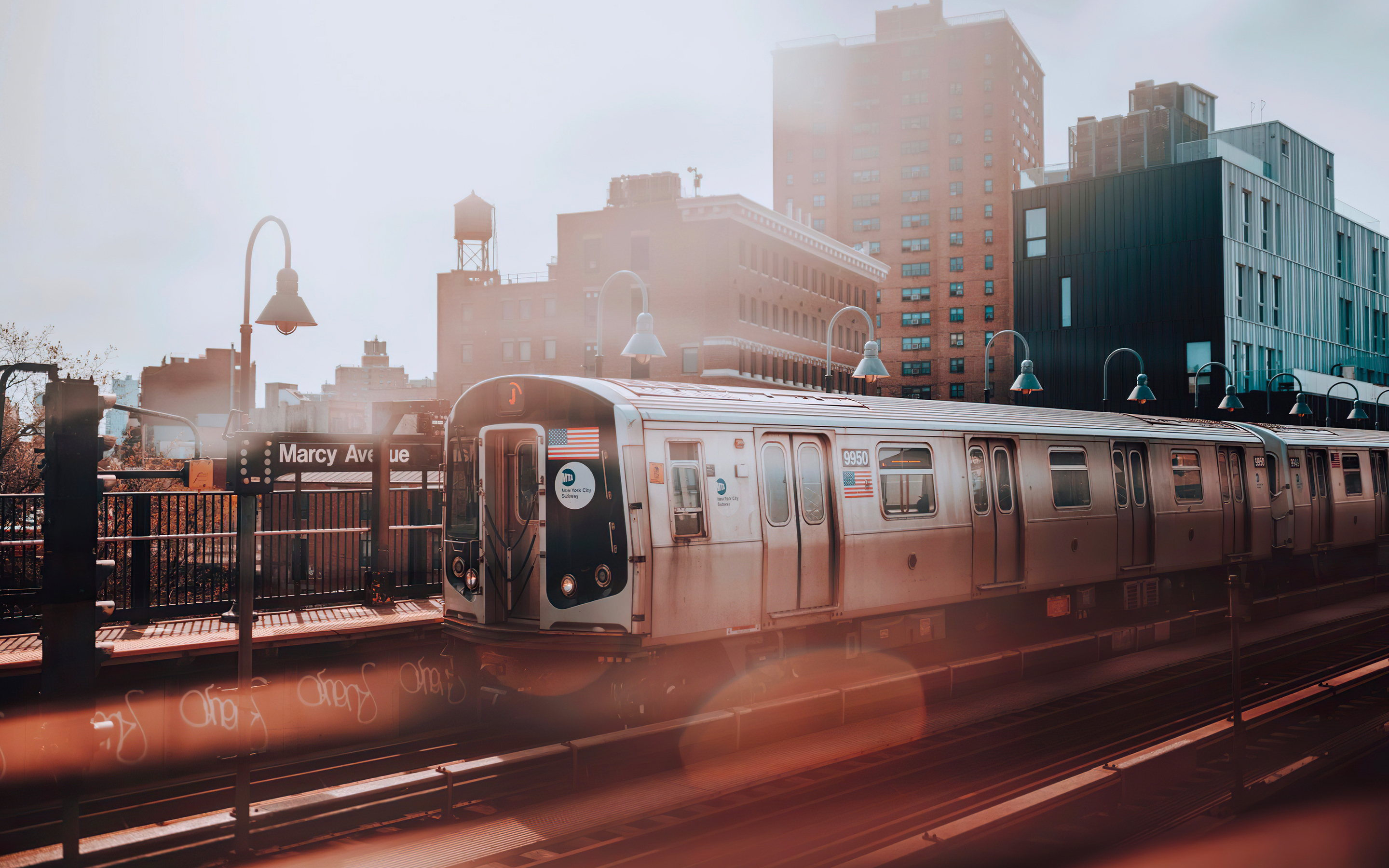 A train passing through a city with tall buildings in the background. - New York