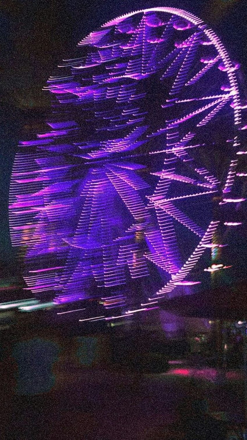 A ferris wheel at night with lights on it - Blurry