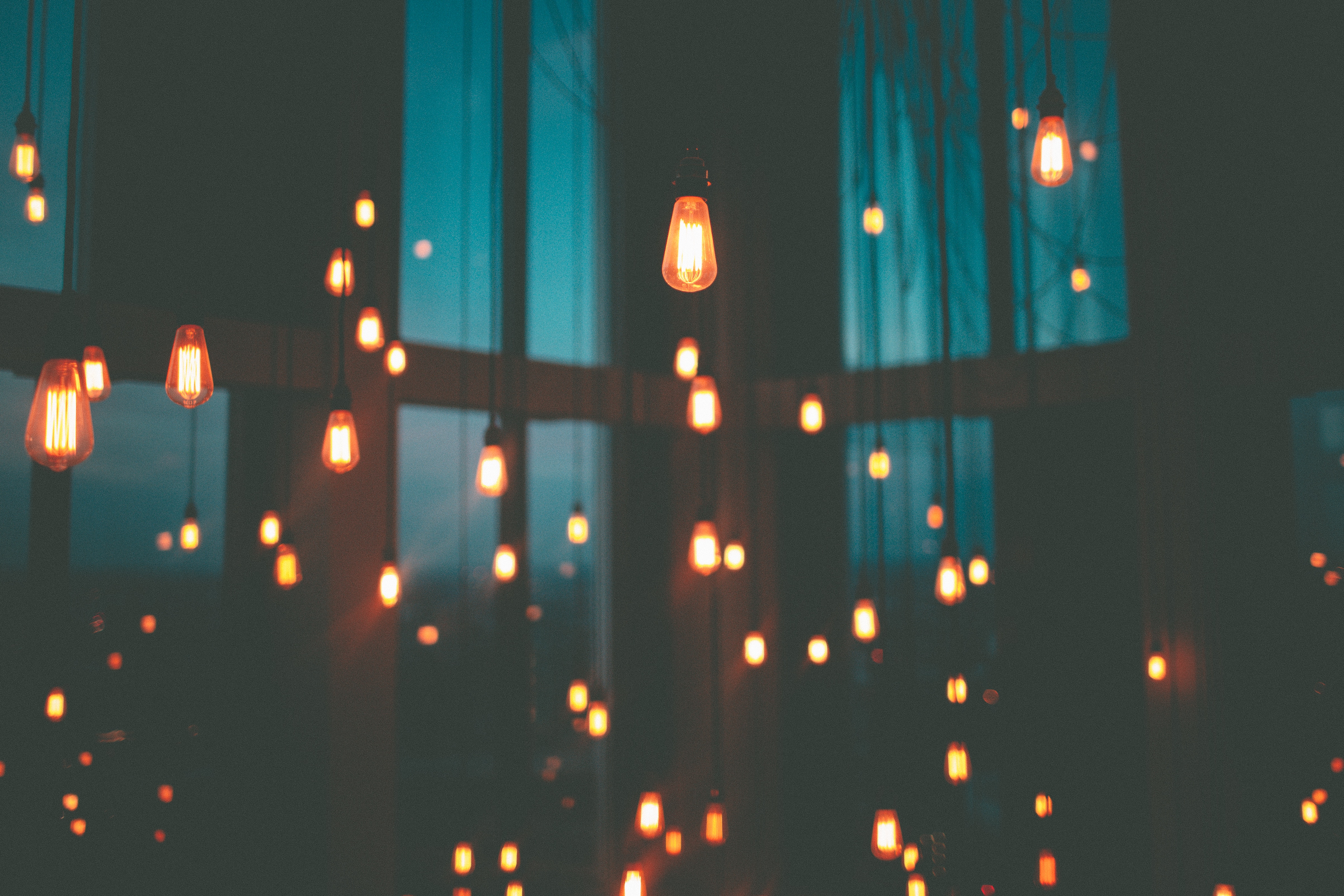 A room with many light bulbs hanging from the ceiling - Blurry