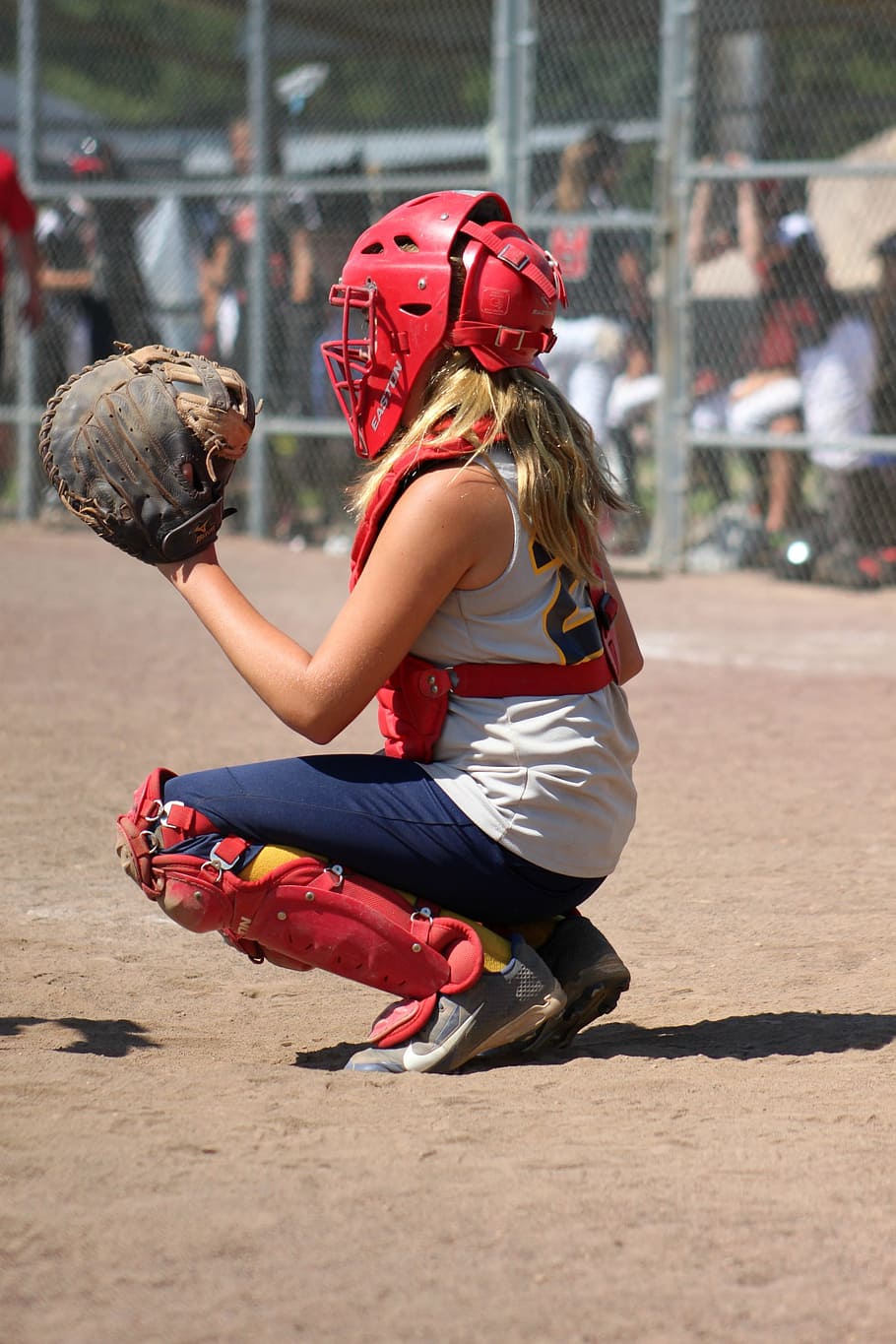 A girl in catcher gear with her glove up - Softball