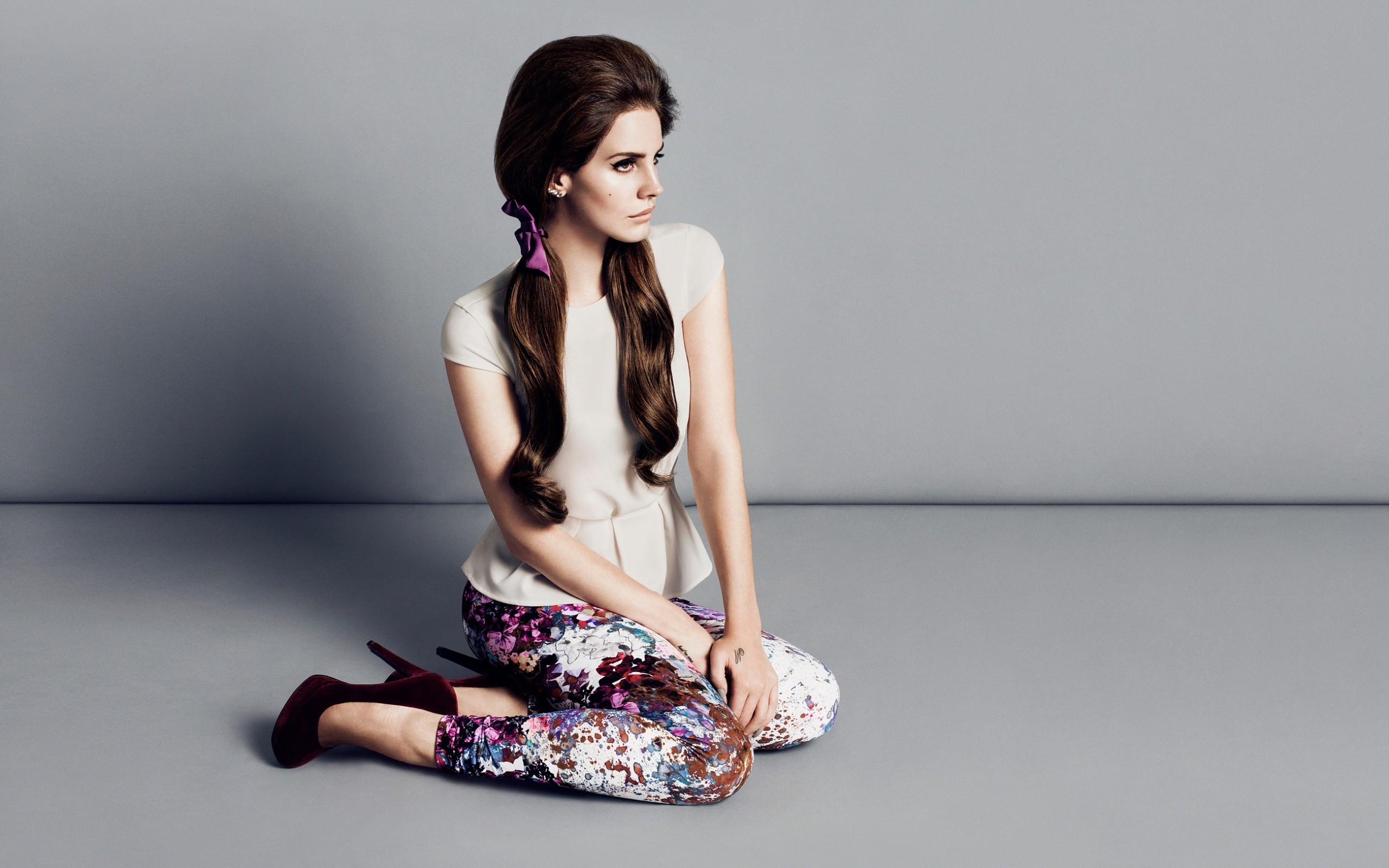 Emma Watson sitting on the floor in a white top and floral pants - Lana Del Rey