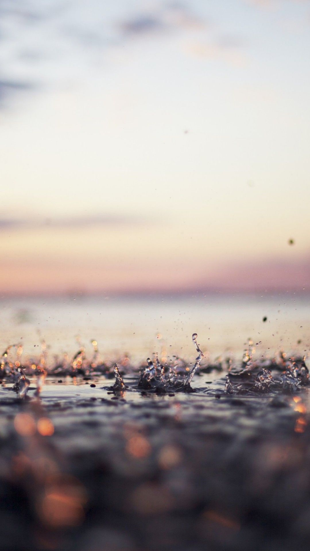 IPhone wallpaper of water splashing on the beach at sunset - Summer