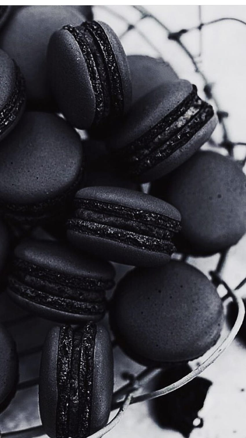 A plate of black macarons with a black and white background - Oreo