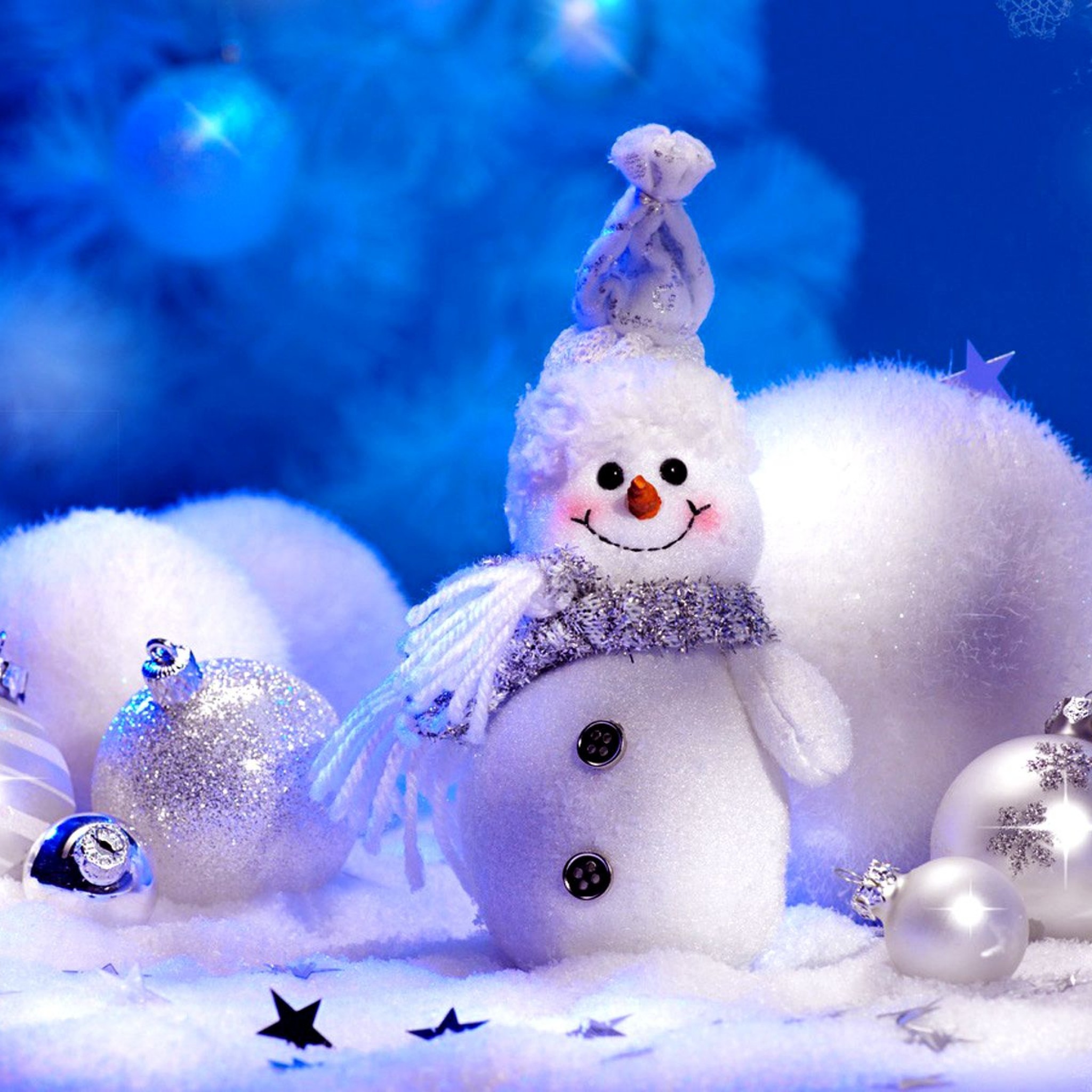 A snowman is sitting in front of some christmas decorations - Christmas