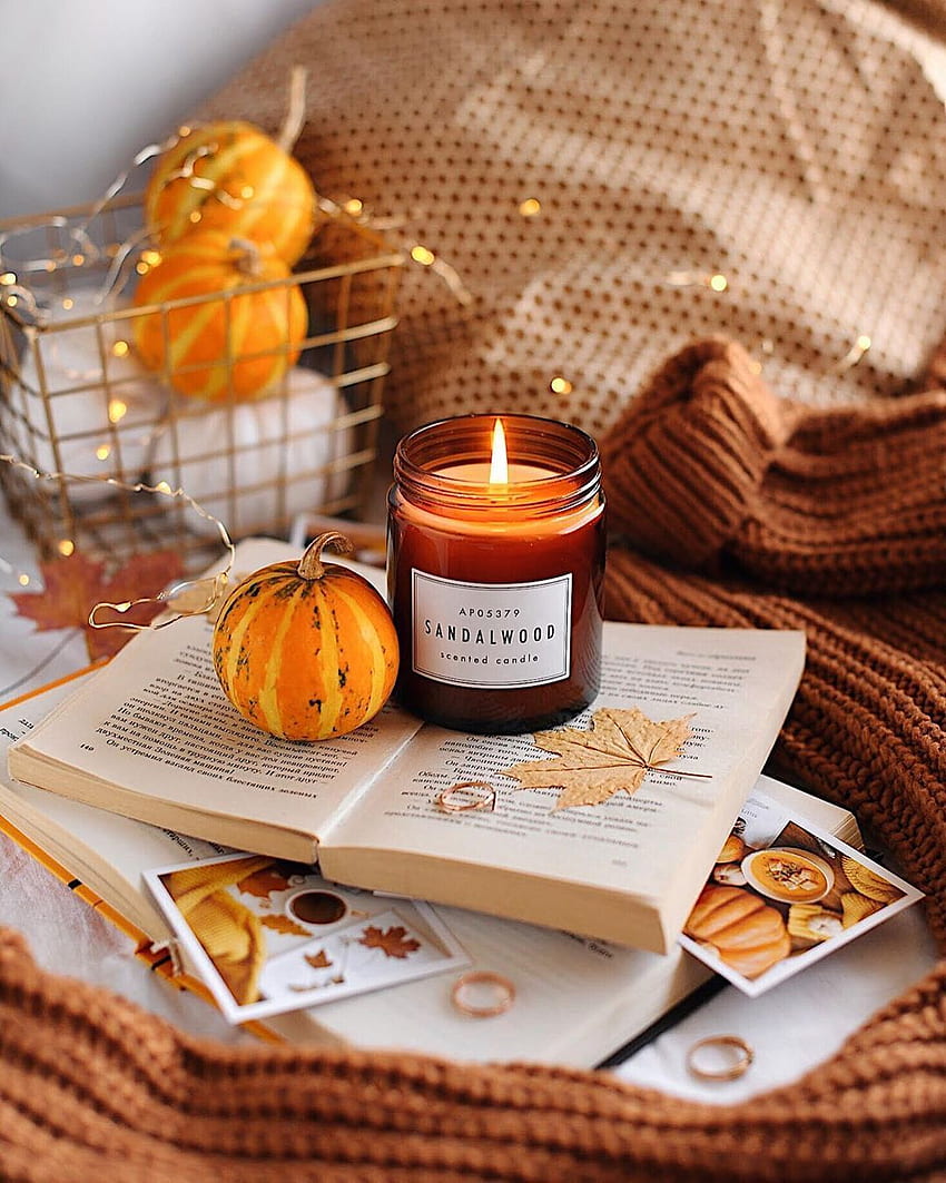 A book with candles and pumpkins on it - Cozy
