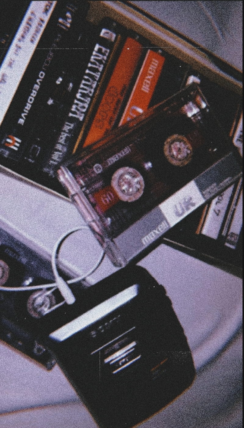 A pile of old cassette tapes and a radio. - 80s