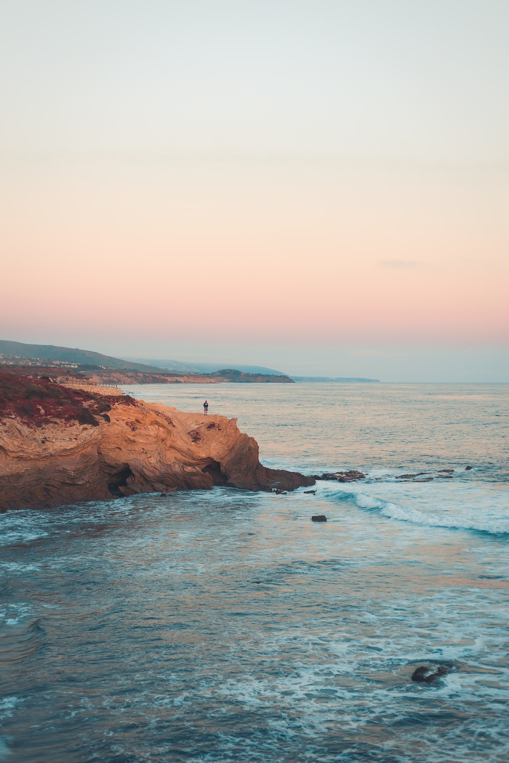 A person standing on the beach looking out at ocean - Witch