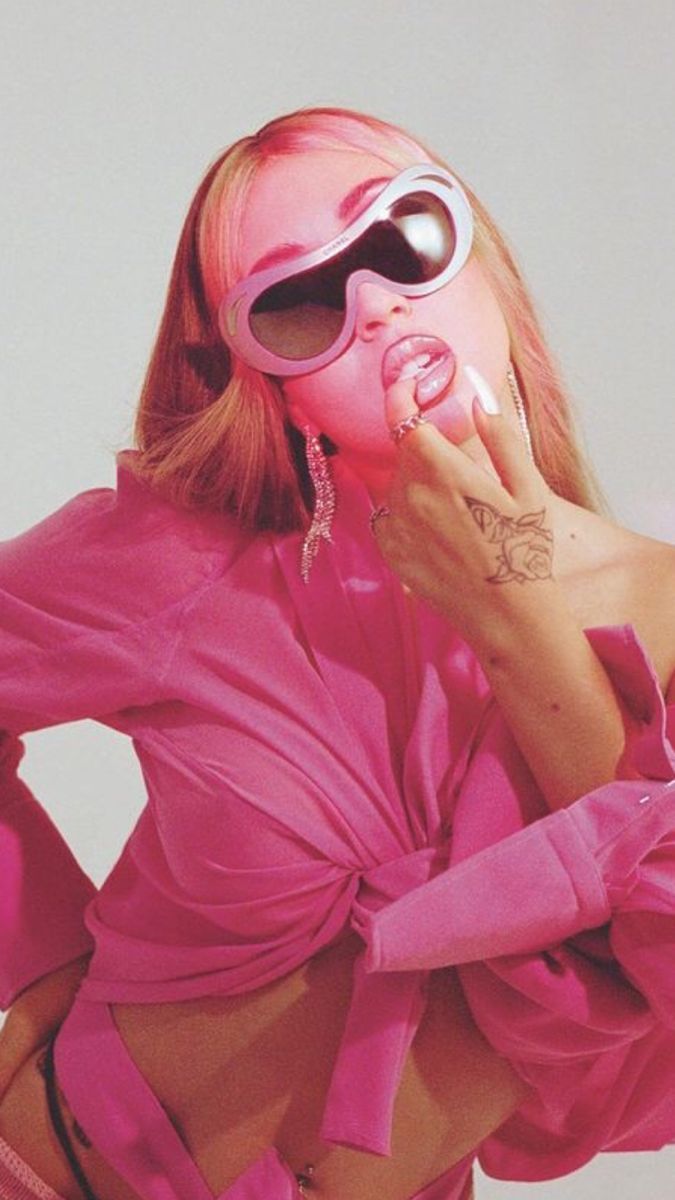 A woman with pink hair and sunglasses. - Kali Uchis