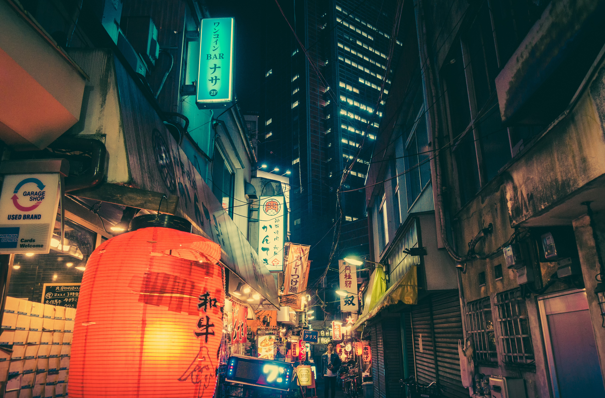 A street at night with many signs and lanterns. - Japan