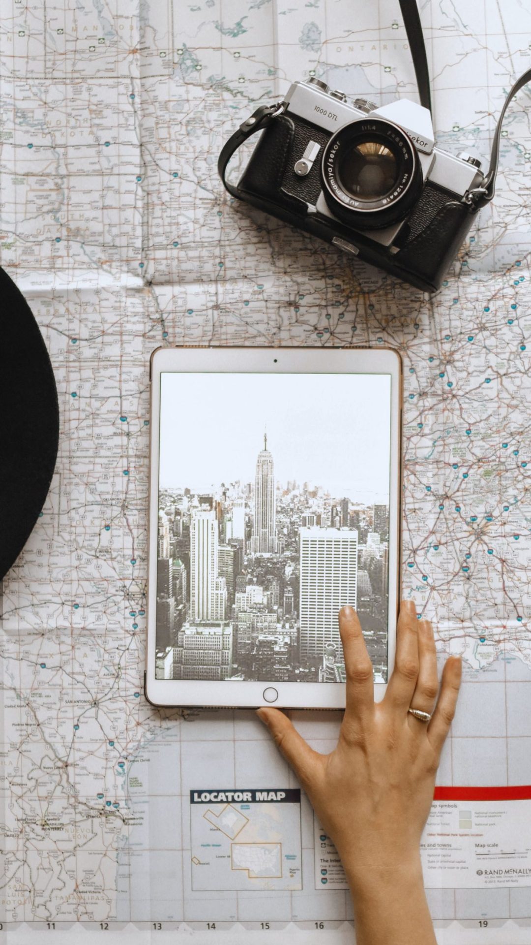 A person is holding up an ipad with the city of new york on it - Travel