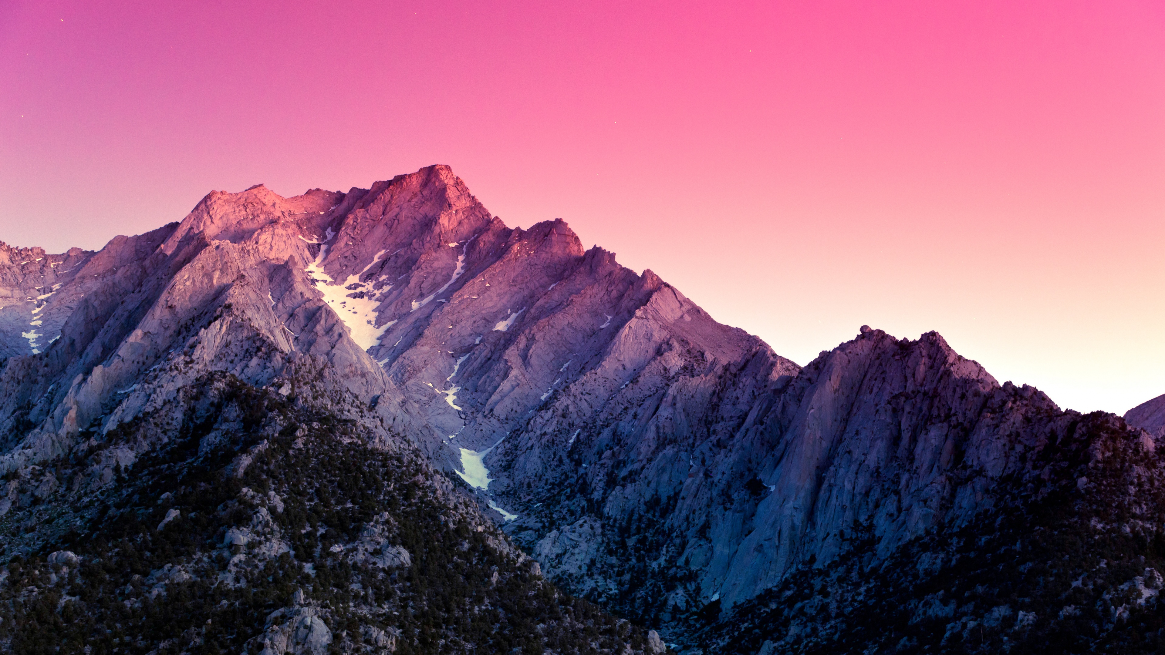 A mountain range with pink sky in the background - Rocks, California