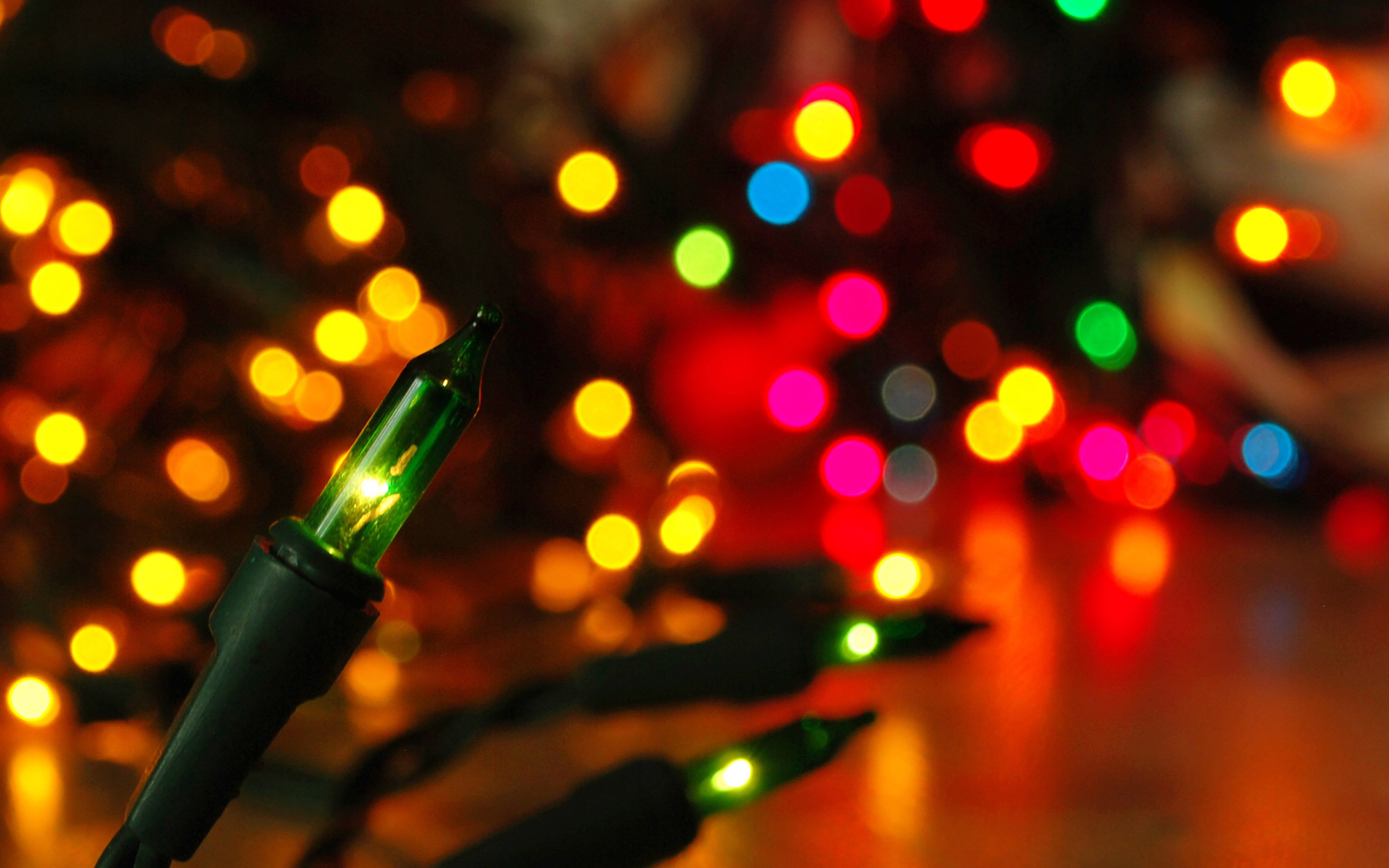 A string of Christmas lights with a focus on the green bulb. - Christmas lights