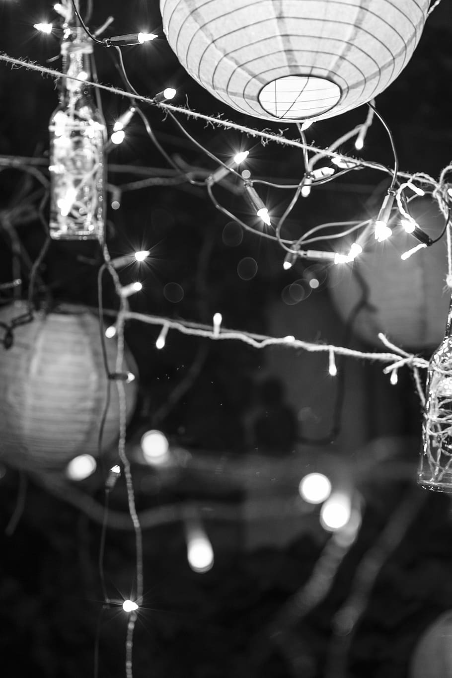 A black and white photo of some lanterns hanging from the ceiling - Christmas lights