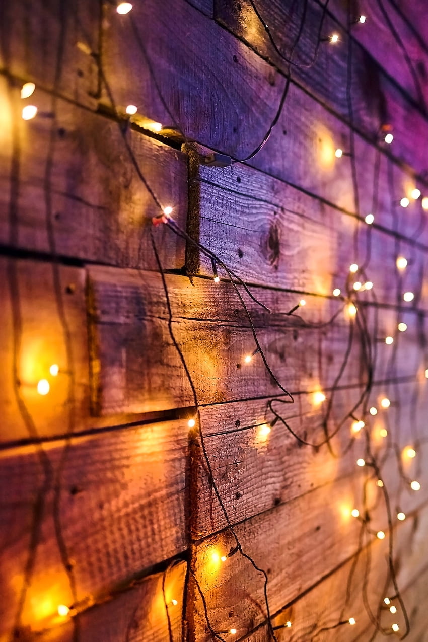 A wooden wall with lights on it - Christmas lights, fairy lights