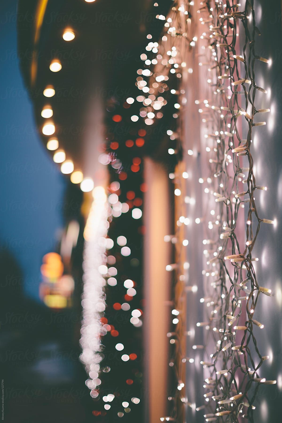 Is a street with christmas lights and some buildings - Christmas lights