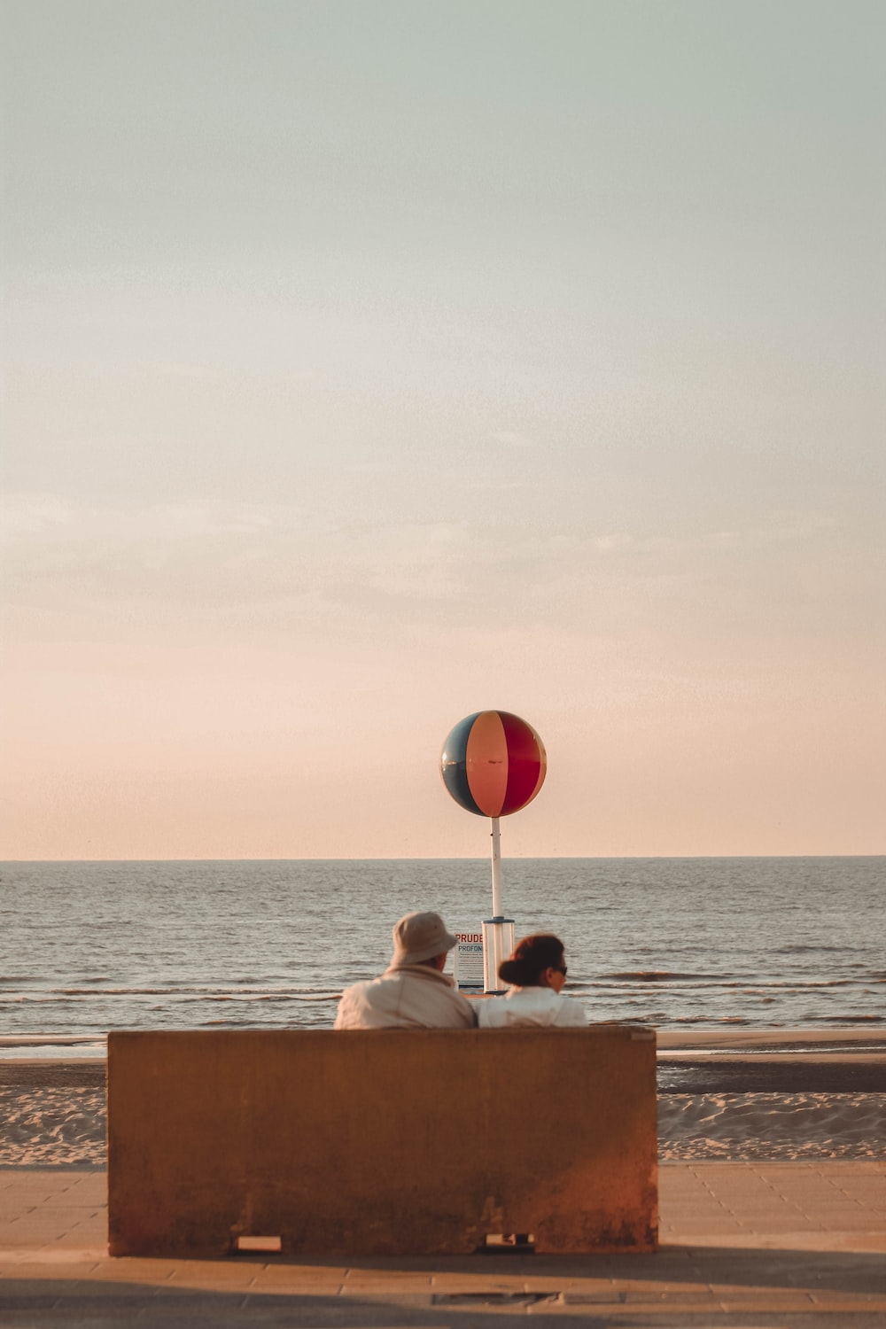 man and woman sitting in front of beach photo