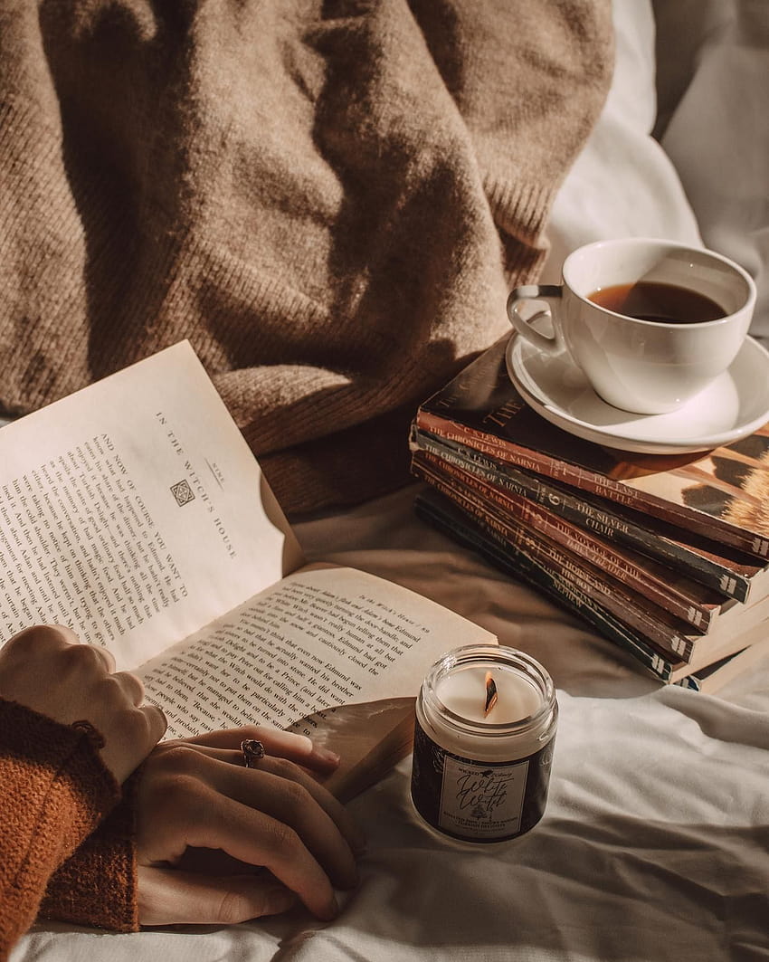 A person reading an open book while drinking coffee - Books