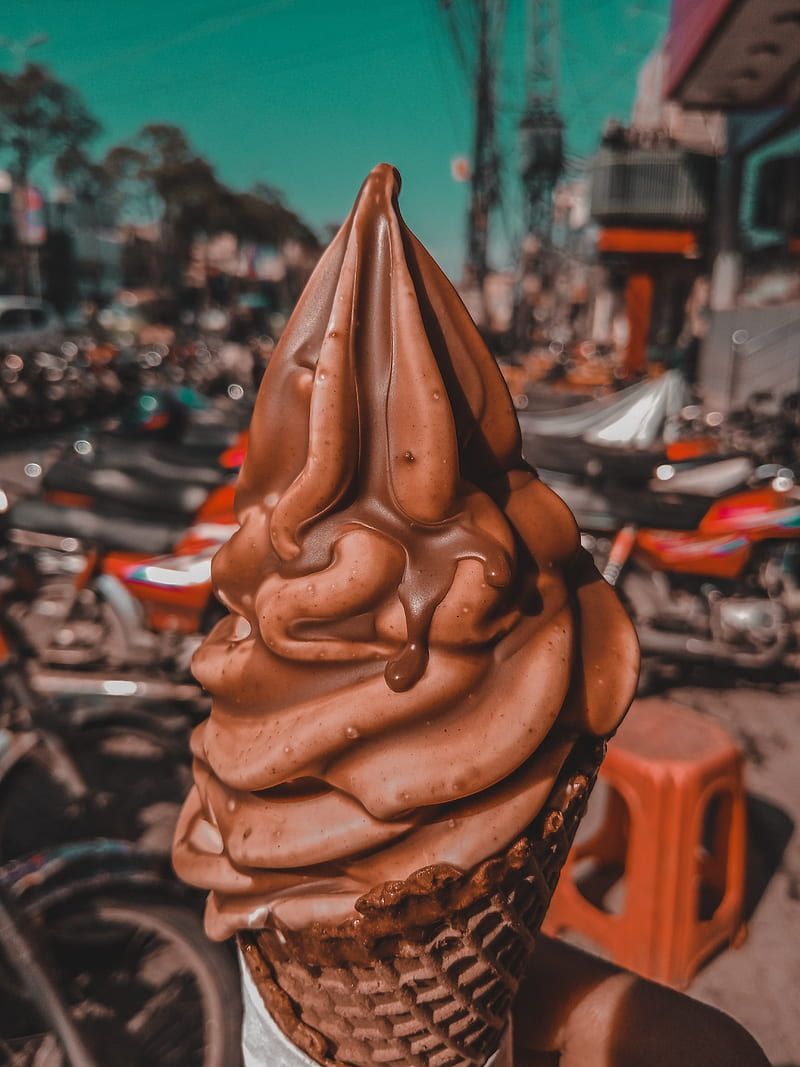 A person holding an ice cream cone in their hand - Ice cream
