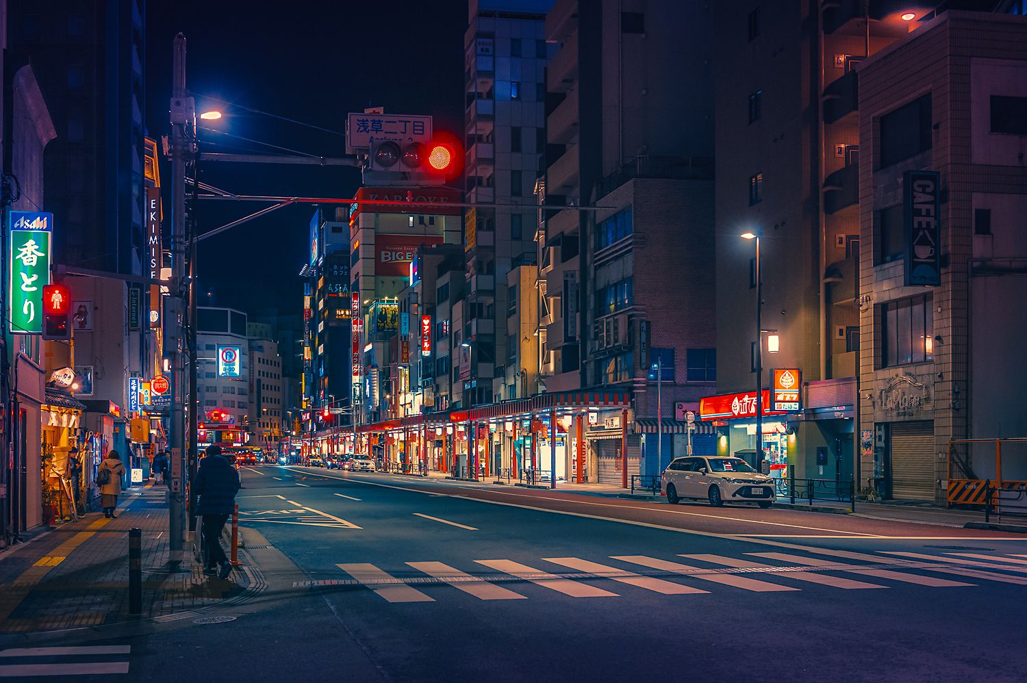 A city street at night with people walking - Tokyo