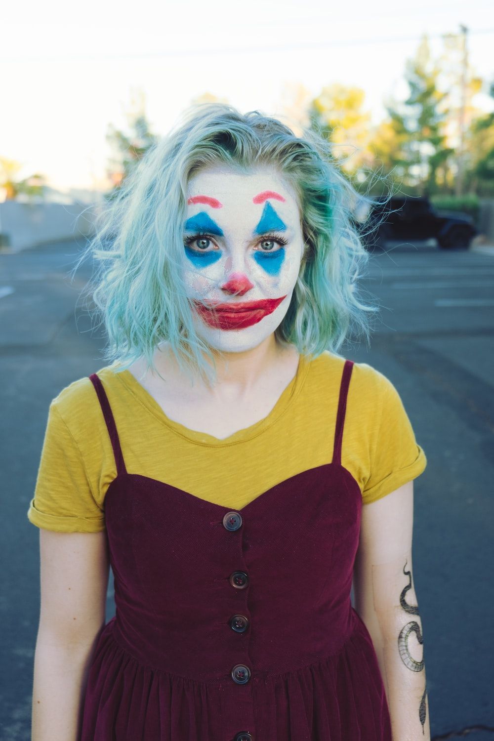 A woman with blue hair and clown makeup - Clown