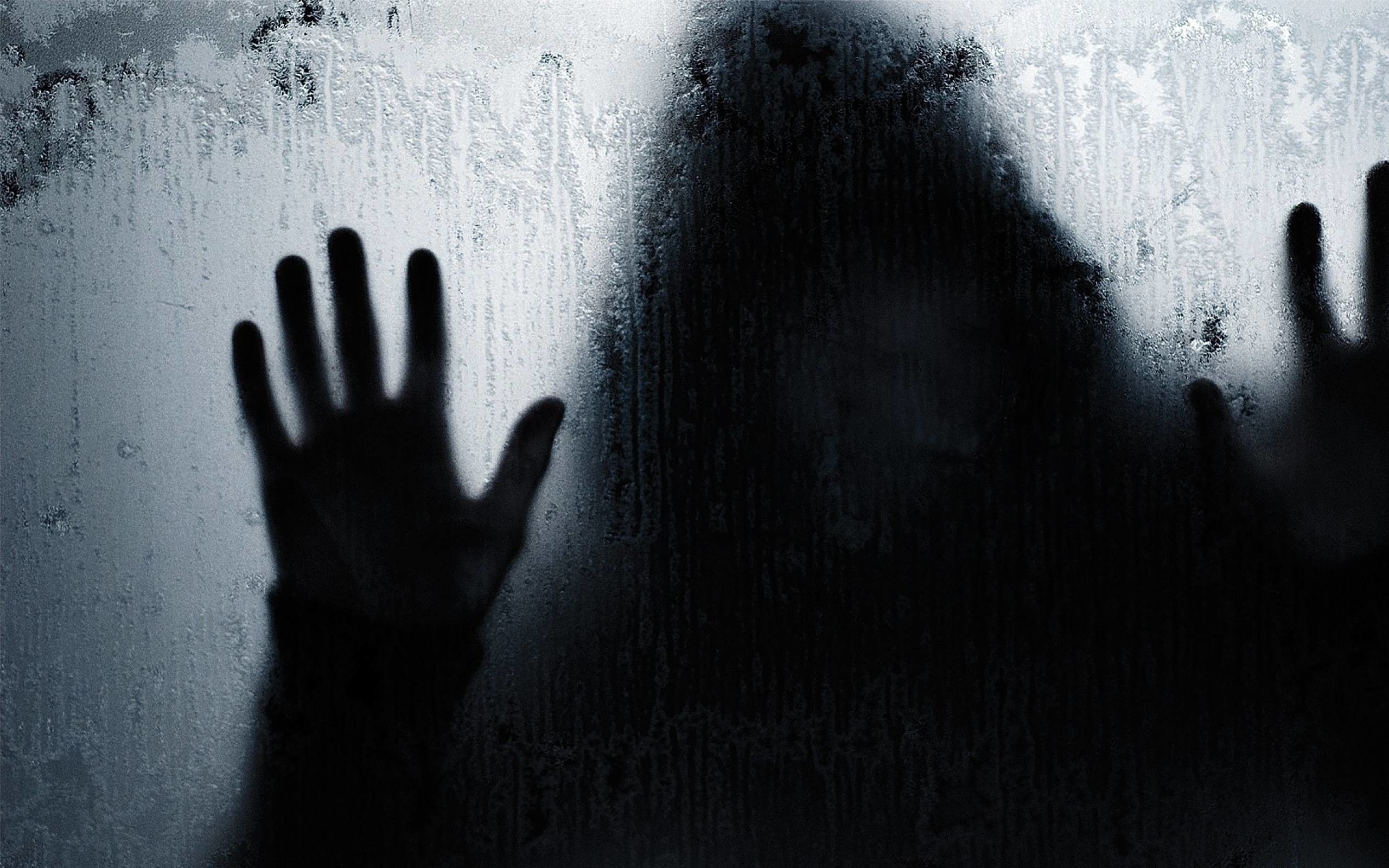 A shadowy figure with hands pressed against a frosted glass window. - Creepy, ghost