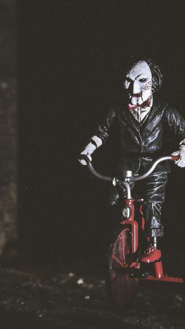 A toy clown riding on top of an old bicycle - Creepy, horror