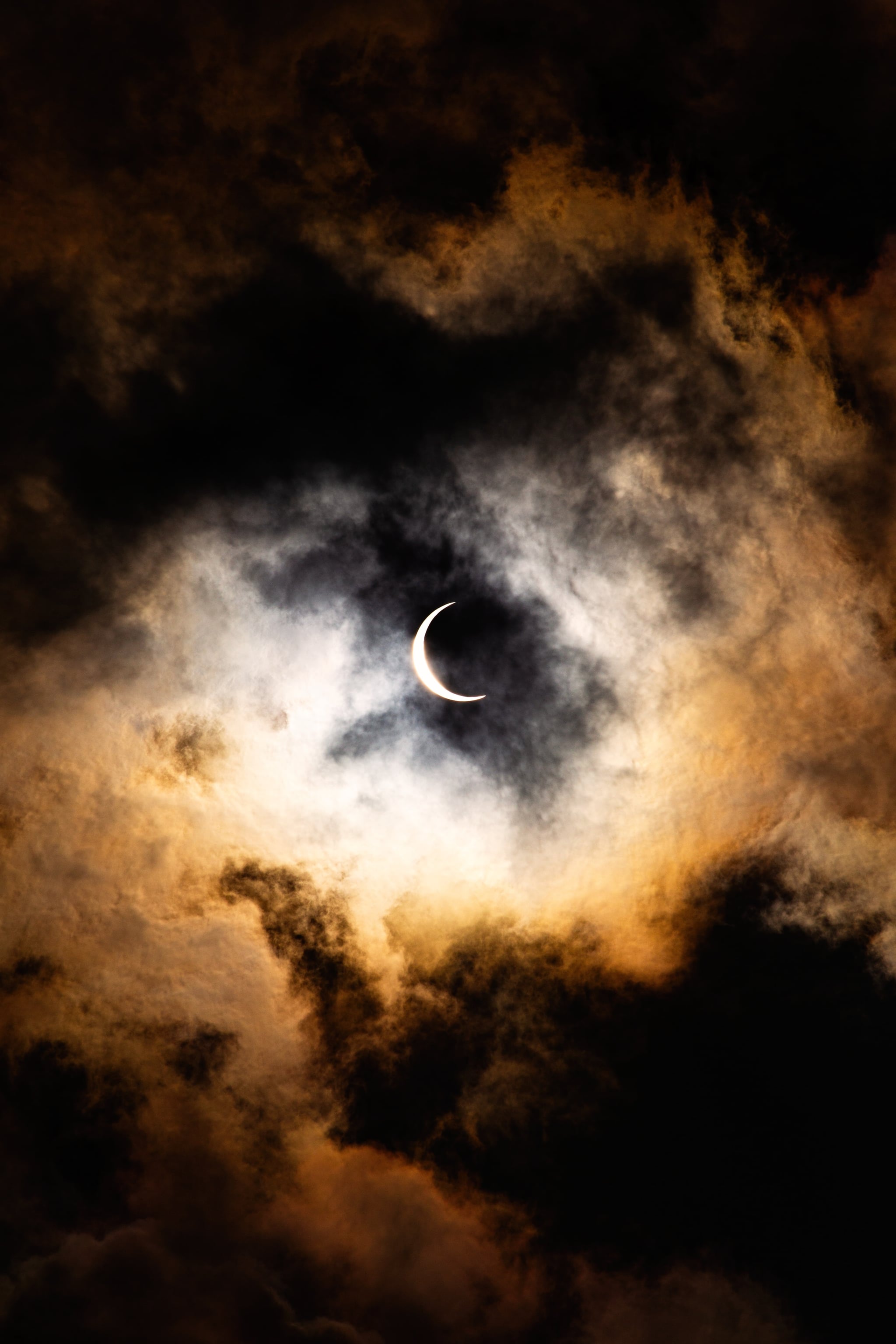 A crescent moon is partially obscured by clouds. - Creepy, spooky