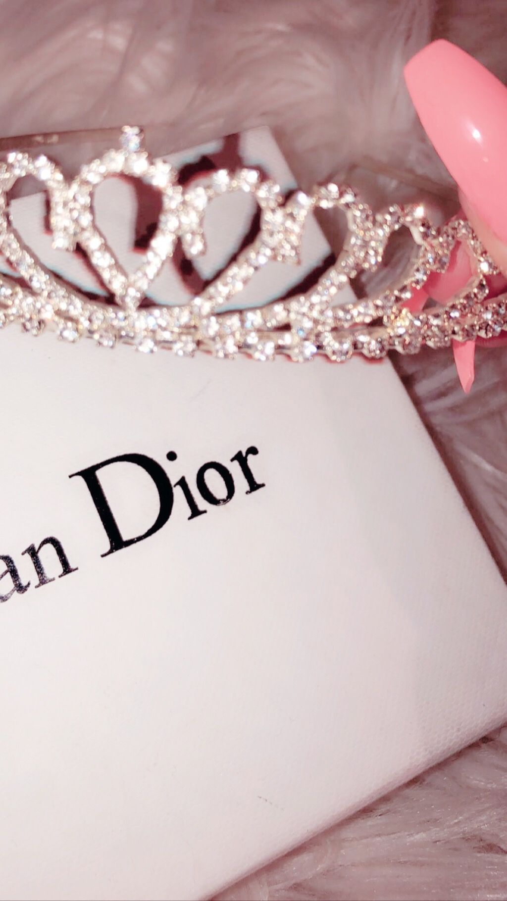 A crown sitting on top of some makeup - Dior, bling