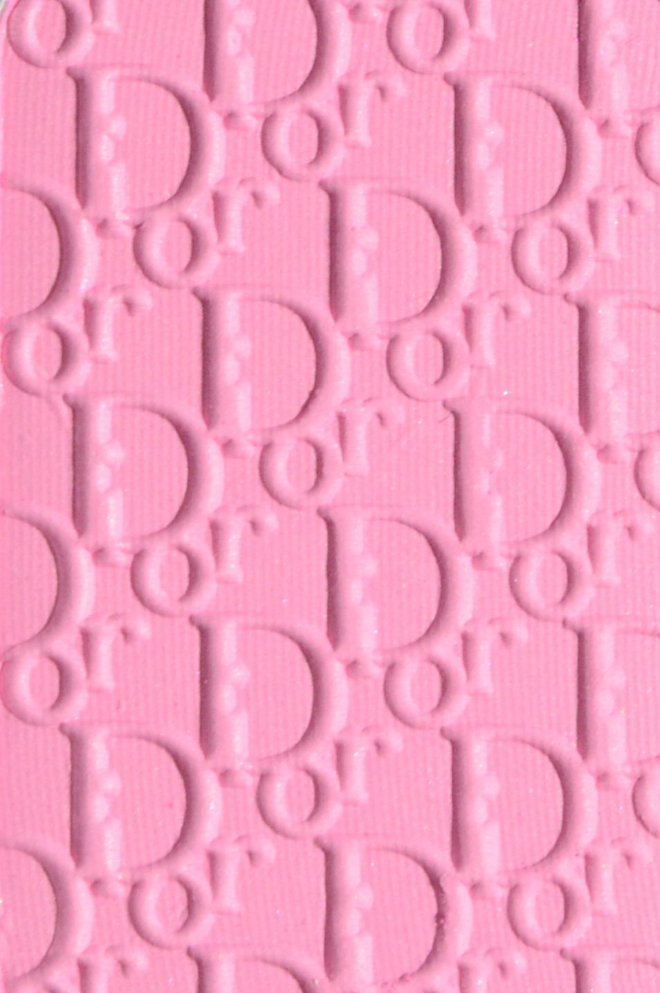 A close up of the Christian Dior logo embossed on a pink background - Dior