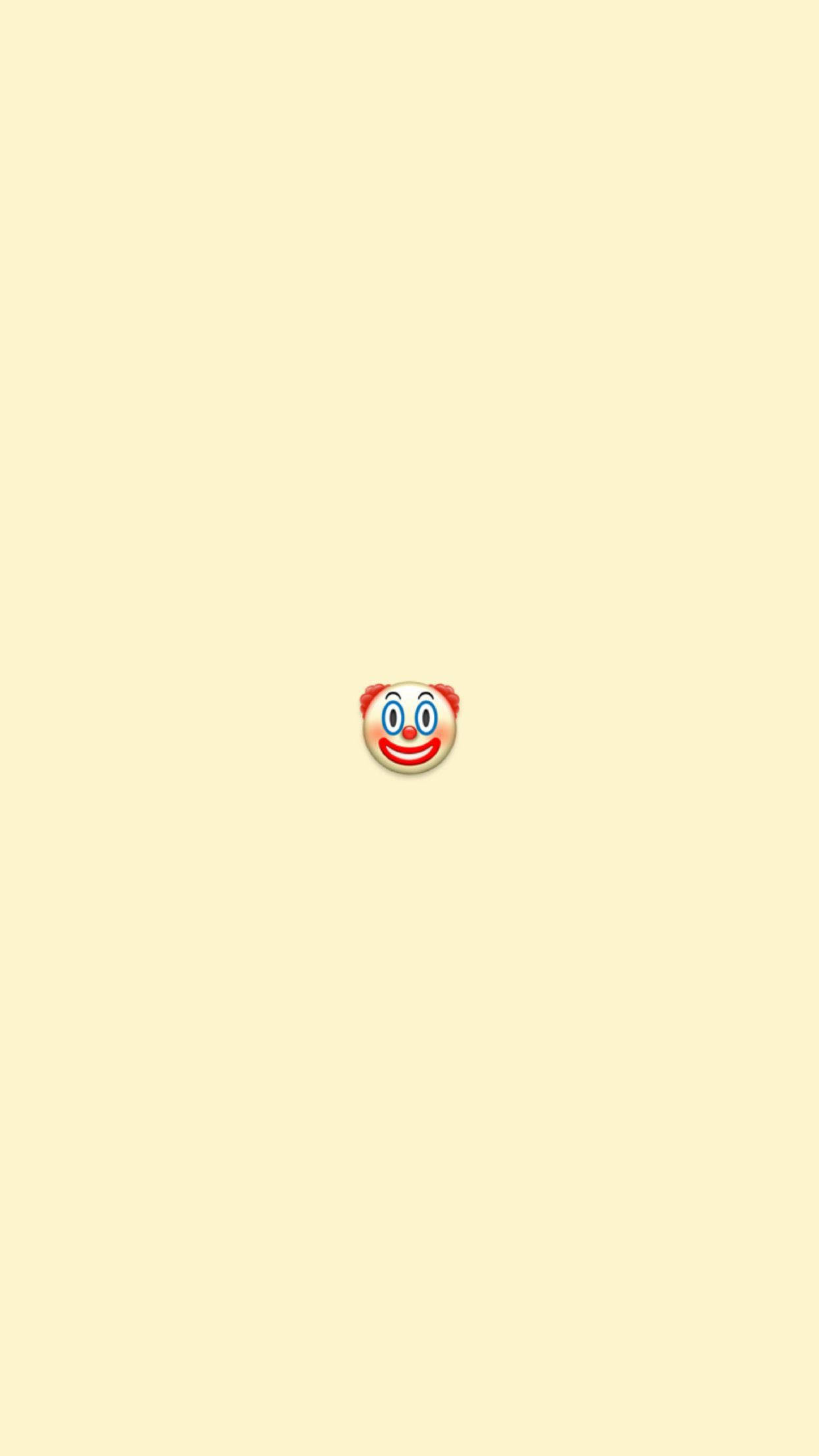 A yellow wallpaper with a red emoticon of a smiling face. - Clown