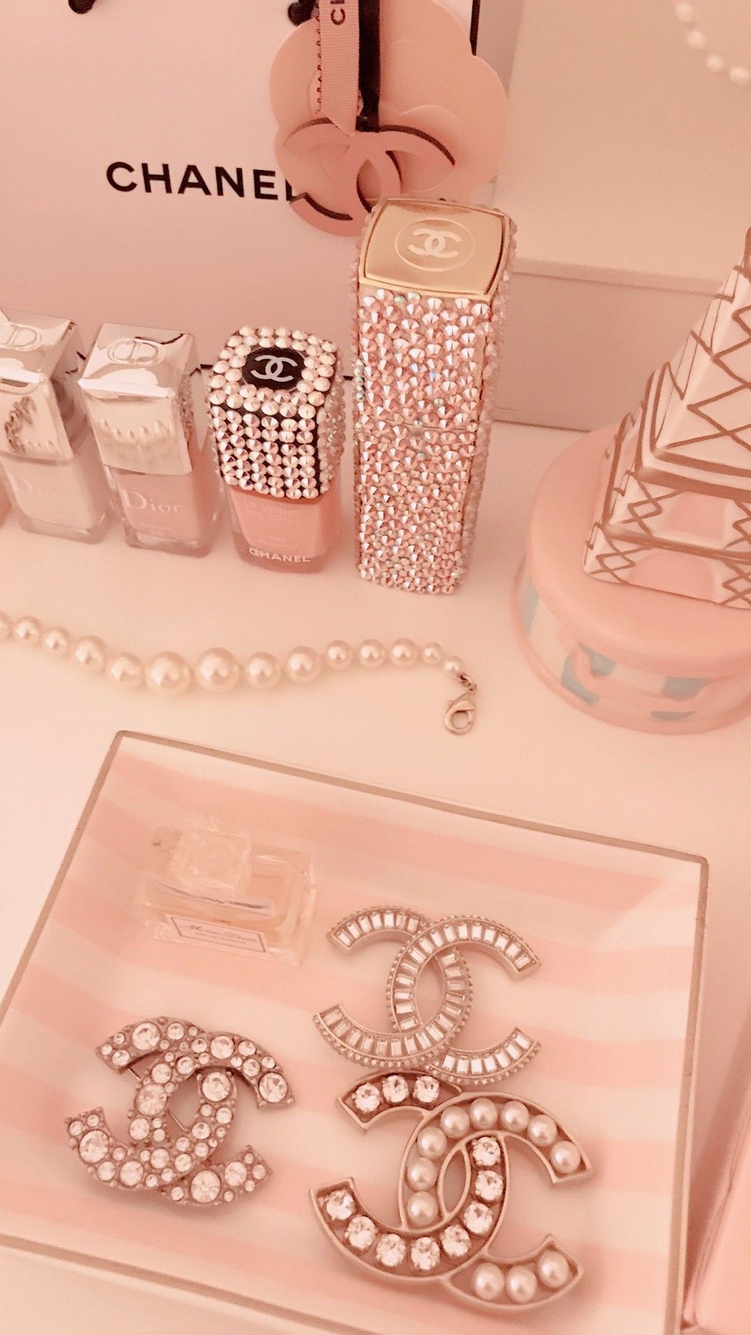 A Chanel makeup bag and Chanel products on a table - Dior