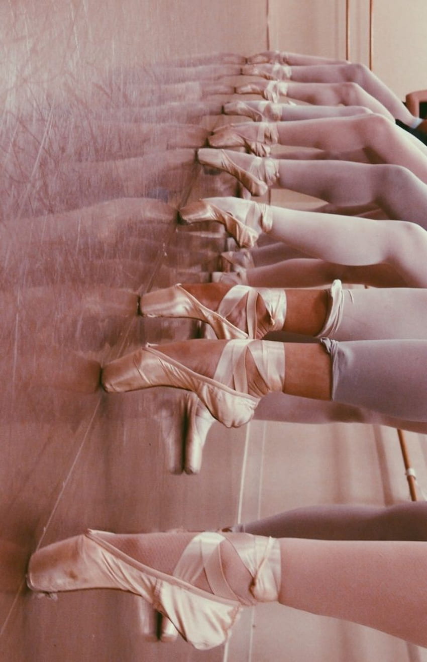 A row of ballerinas' legs in pointe shoes, as seen from above. - Ballet