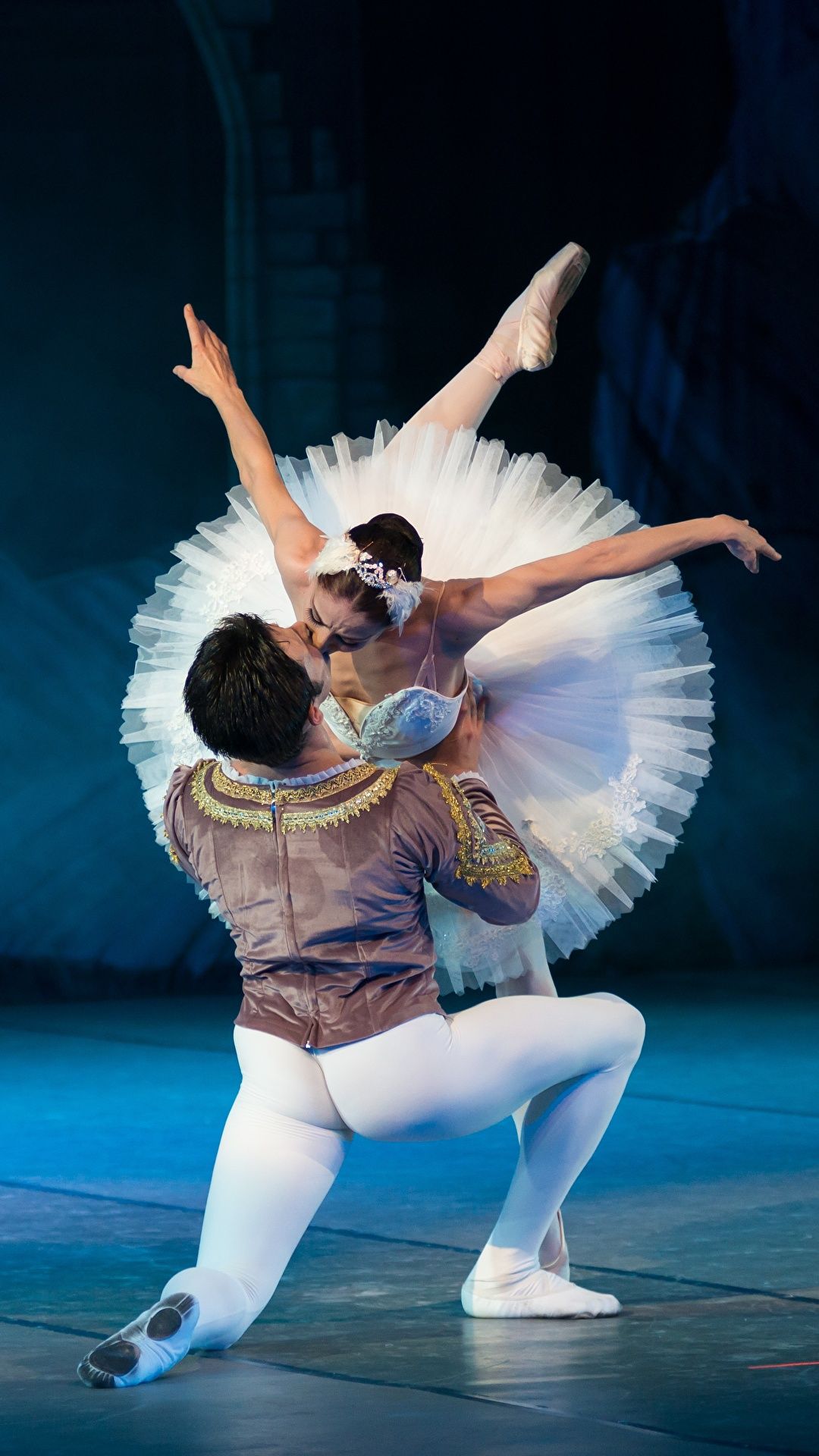 A male and female ballet dancer on stage, the female is in a卿吻姿势 with her arms and legs extended, the male is in a kneeling position facing the female - Ballet