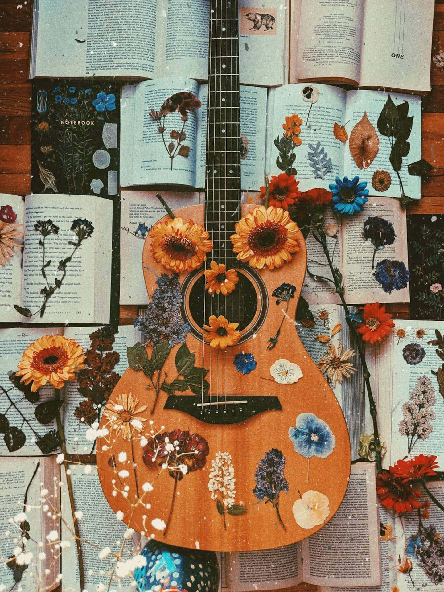 A guitar with flowers on it and books - Guitar