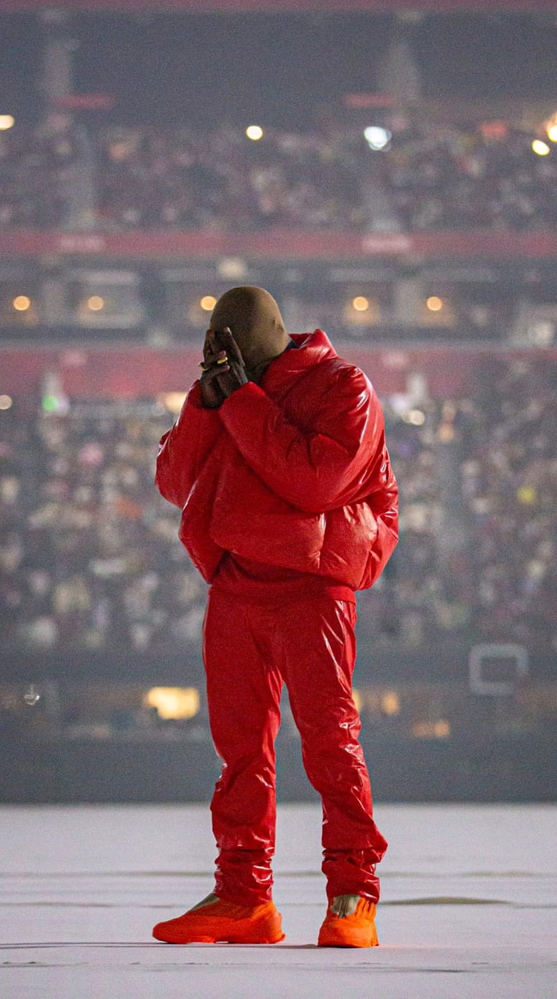 Kanye West performs at the 2020 Grammys in a red outfit and orange shoes - Kanye West