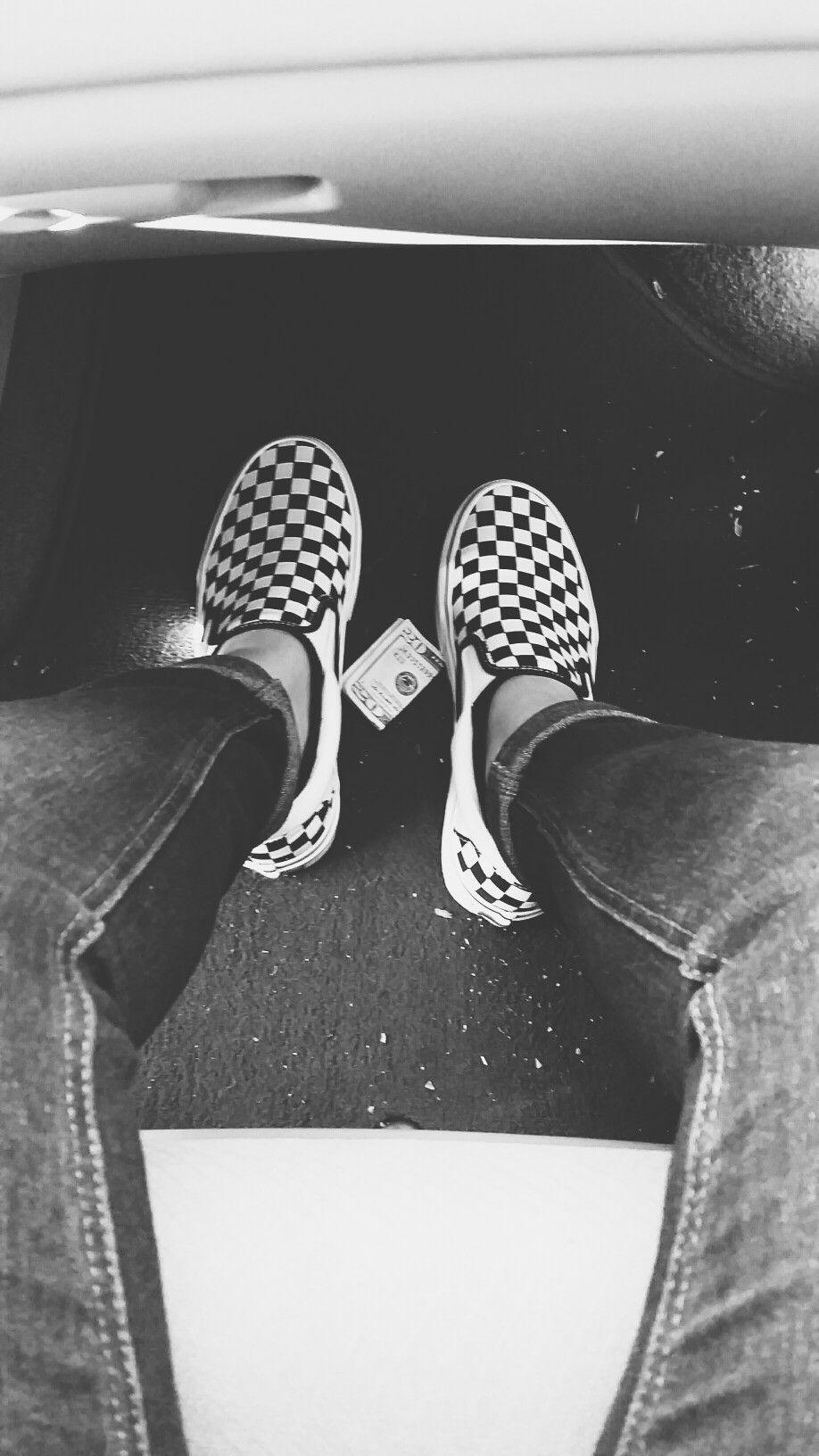 A person wearing checkered vans shoes. - Vans