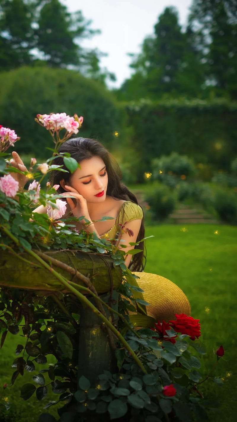 A woman sitting on the ground with flowers - Garden