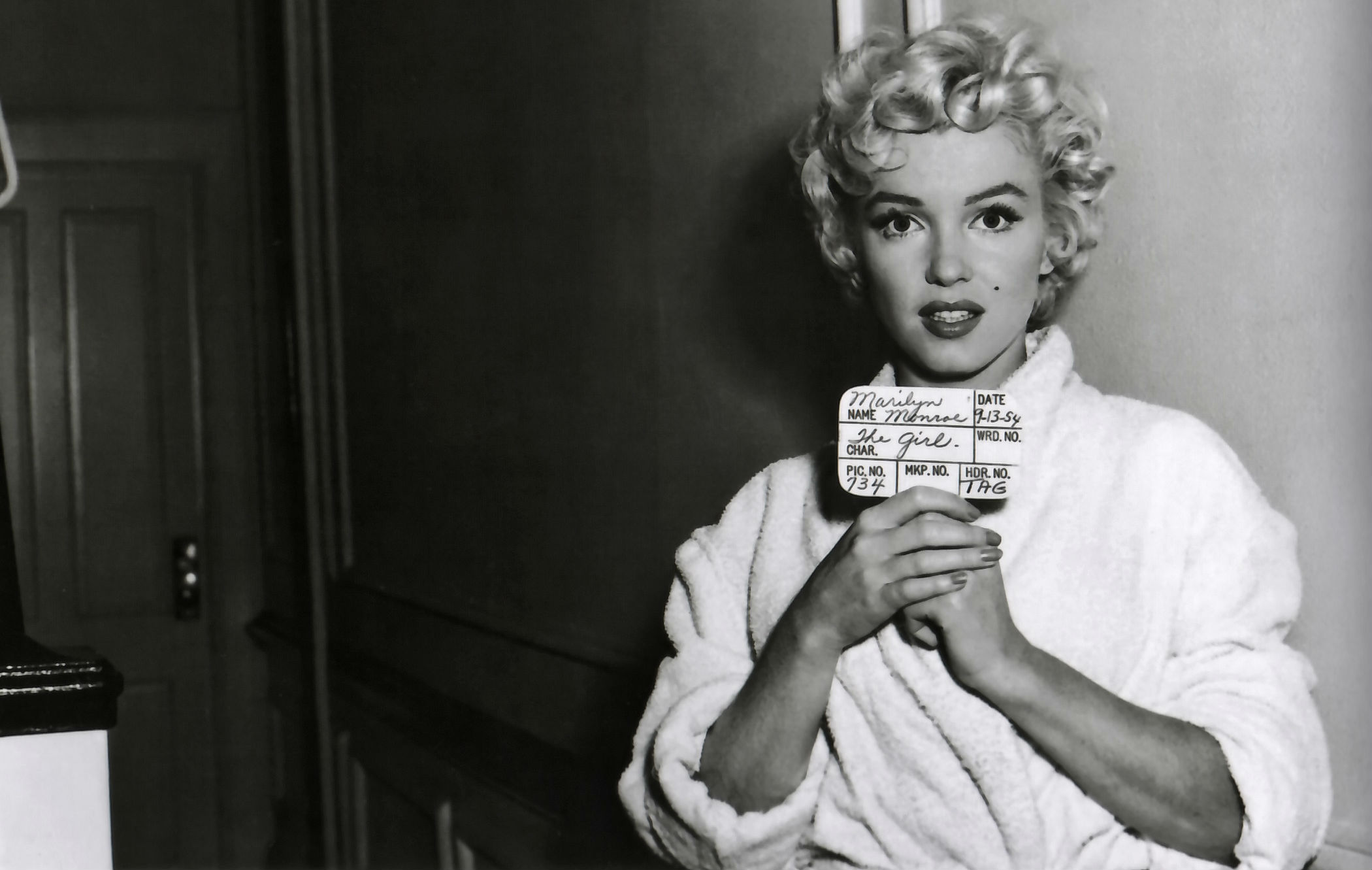 A behind the scenes shot of Marilyn Monroe holding a clapperboard - Marilyn Monroe