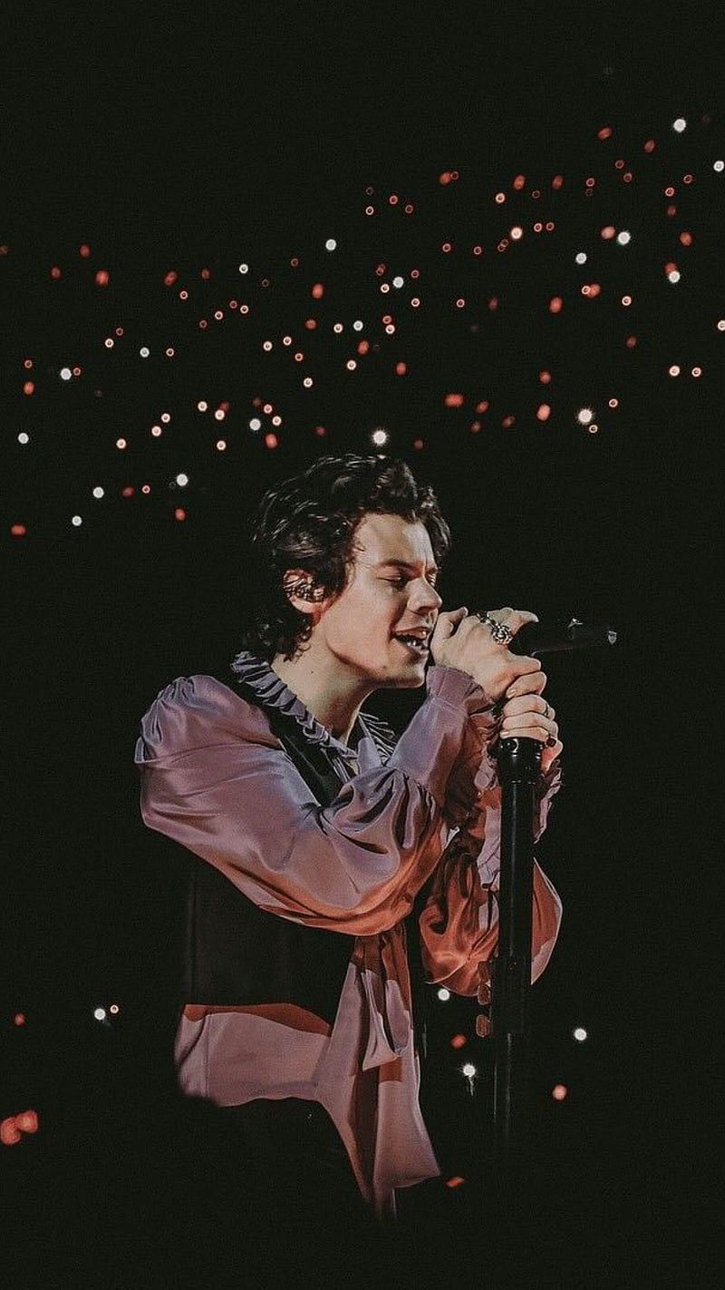 A man singing into the microphone at night - One Direction, Harry Styles