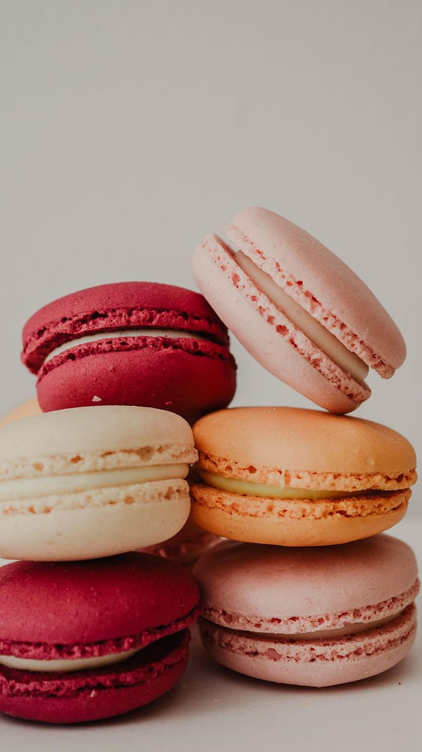 A stack of colorful macarons on a white surface - Bakery