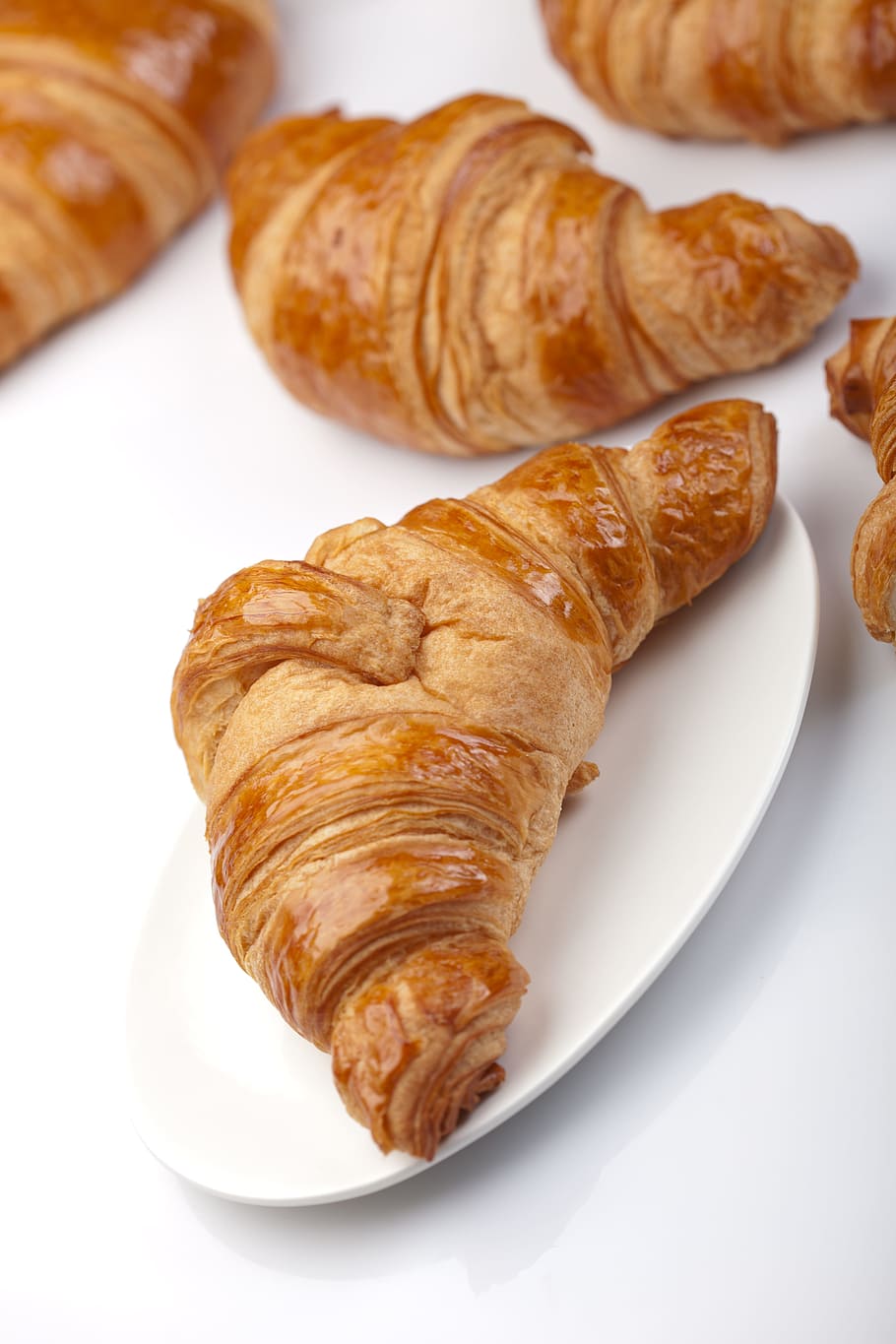 Croissants on a white plate on a white table - Bakery