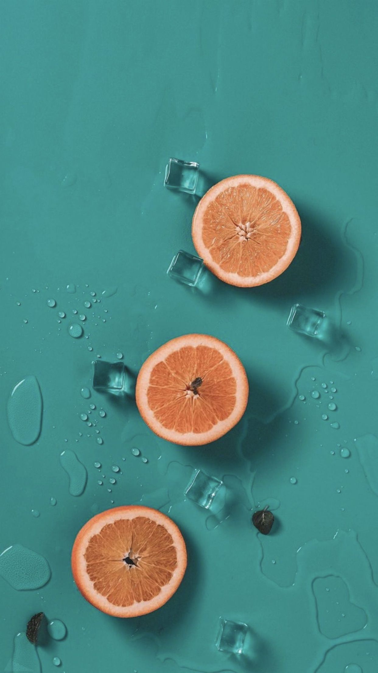 A couple of oranges are floating in water - Foodie
