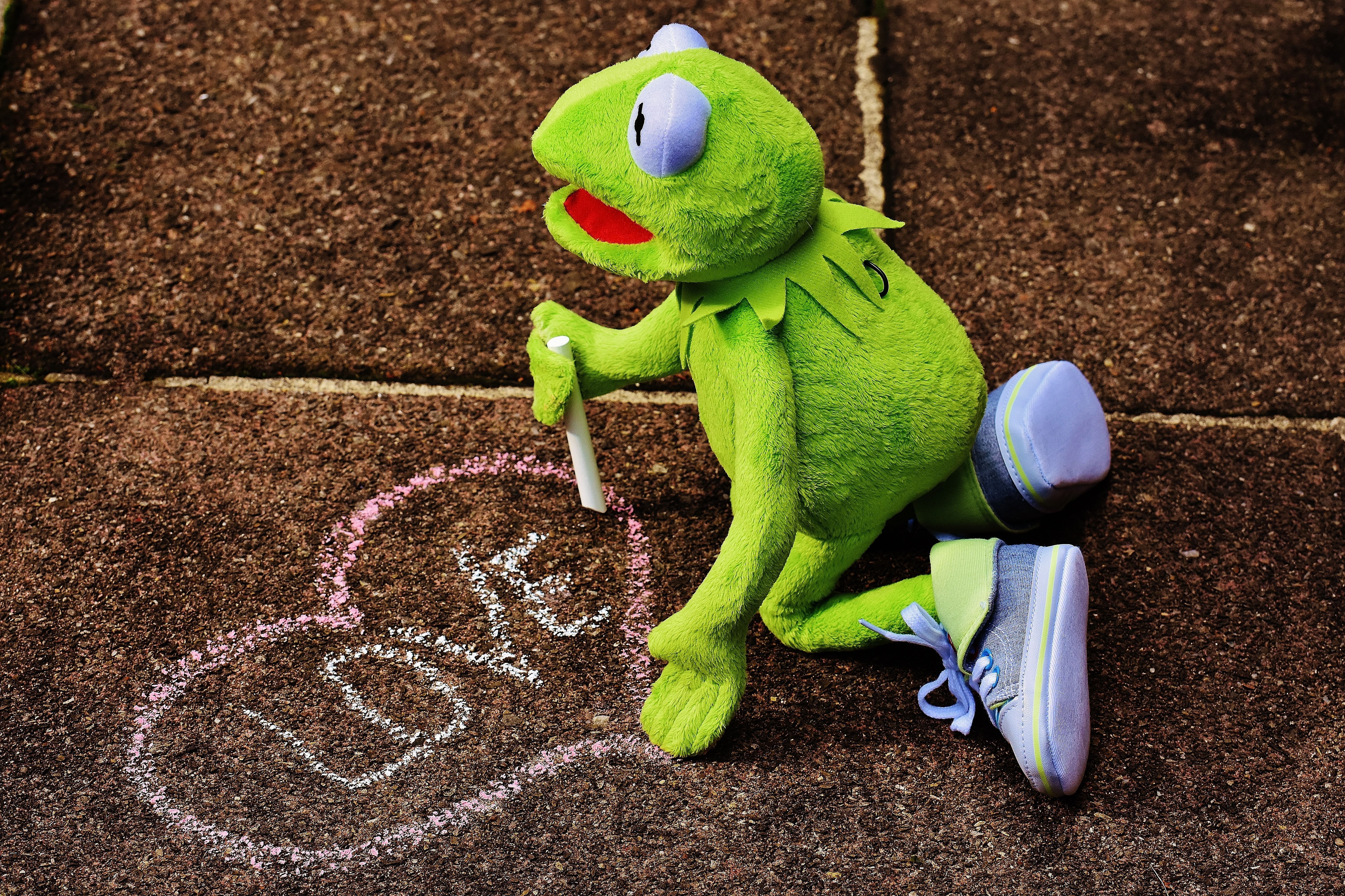 Kermit the Frog drawing a heart with sidewalk chalk. - Kermit the Frog